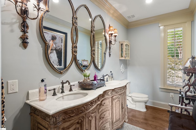 bathroom featuring toilet, hardwood / wood-style floors, vanity, and ornamental molding