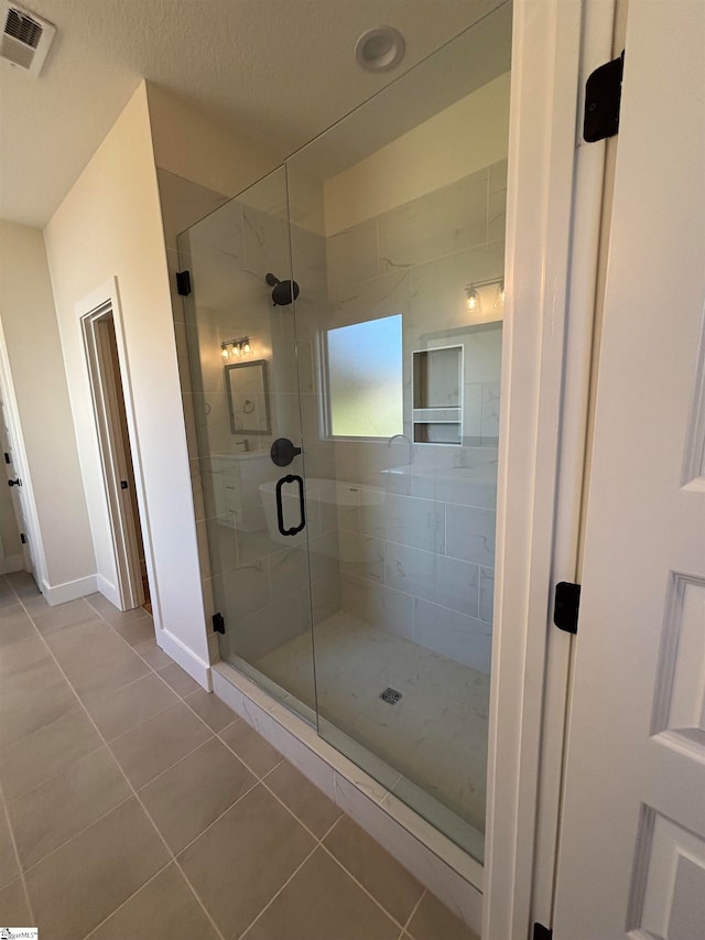 bathroom featuring tile patterned floors and a shower with door