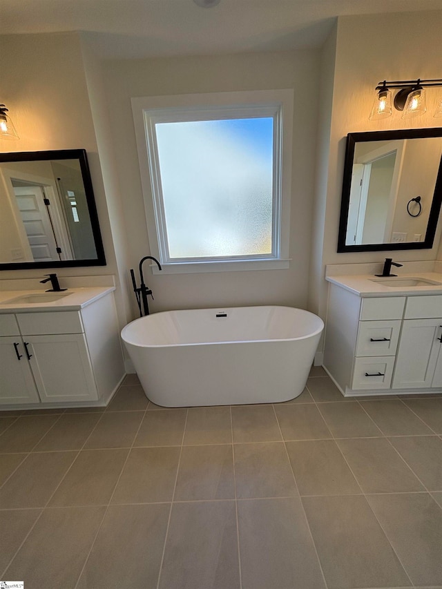 bathroom with a bath, tile patterned floors, and vanity