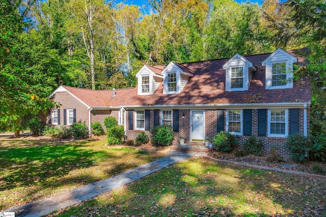 cape cod home with a front yard