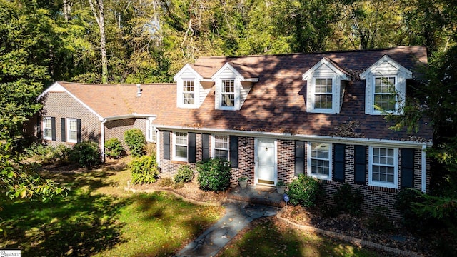 new england style home featuring a front lawn