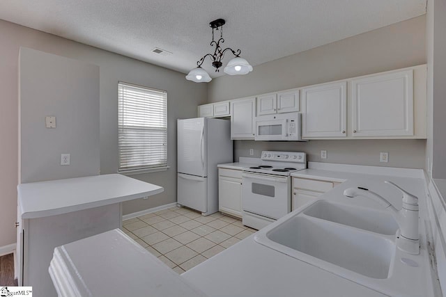 kitchen with hanging light fixtures, sink, an inviting chandelier, white cabinetry, and white appliances