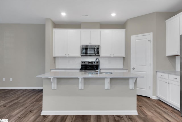 kitchen featuring a center island with sink, appliances with stainless steel finishes, and white cabinets