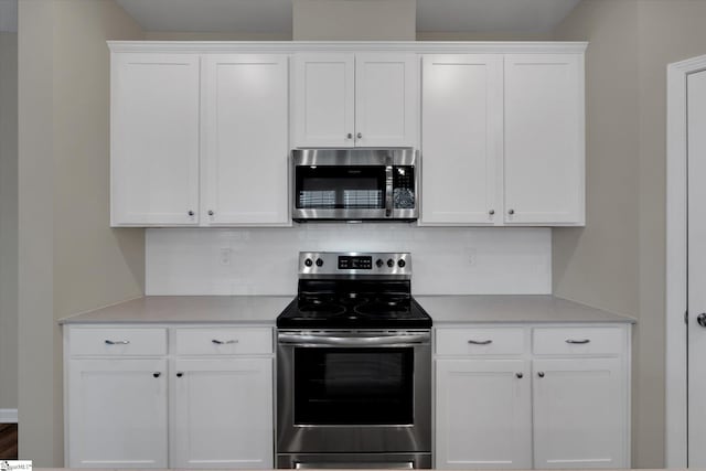 kitchen featuring appliances with stainless steel finishes, decorative backsplash, and white cabinets