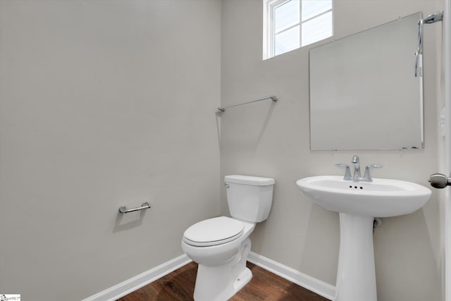 bathroom with toilet, sink, and hardwood / wood-style floors