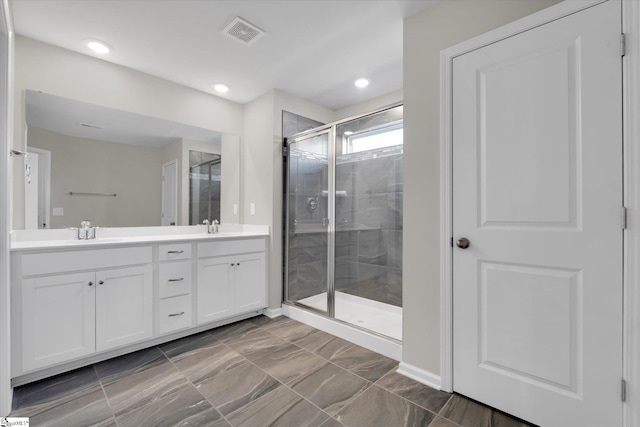 bathroom featuring vanity and a shower with door