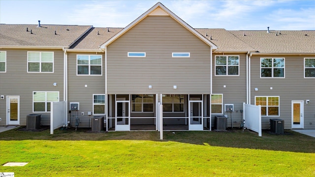 back of property with central air condition unit, a lawn, and a sunroom