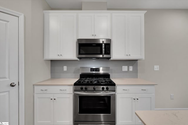 kitchen featuring appliances with stainless steel finishes, white cabinets, and tasteful backsplash