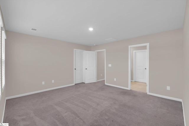 unfurnished bedroom with light colored carpet