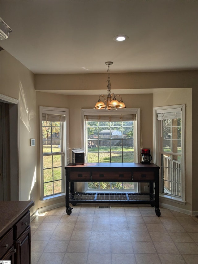 tiled dining area featuring a wealth of natural light and a notable chandelier