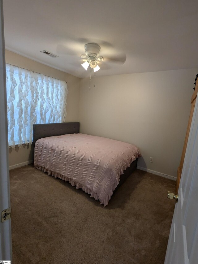 bedroom featuring ceiling fan and dark carpet