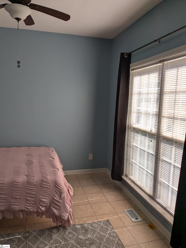 bedroom with ceiling fan and light tile patterned flooring