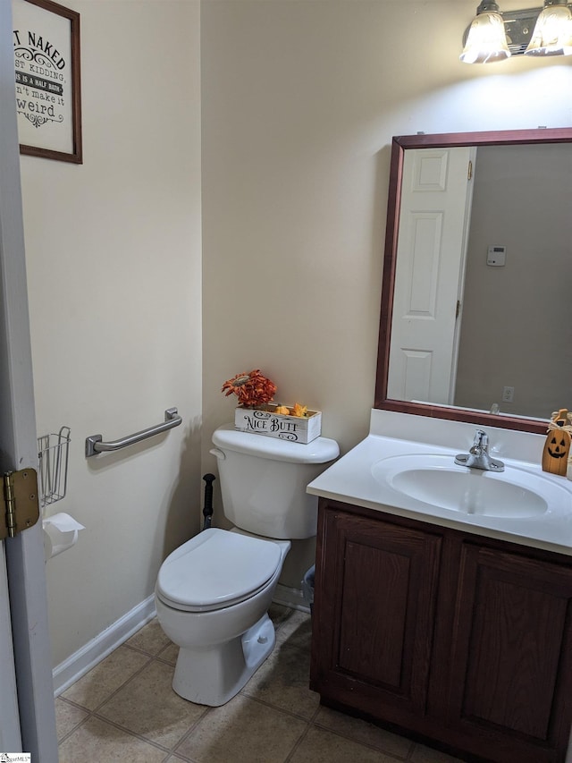 bathroom featuring toilet, vanity, and tile patterned flooring