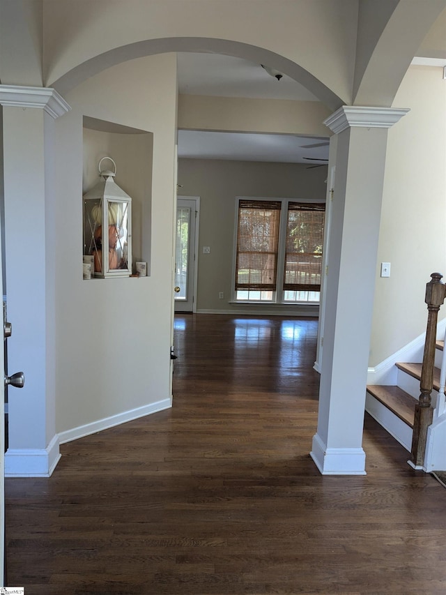 interior space featuring ornate columns, dark wood-type flooring, and ceiling fan