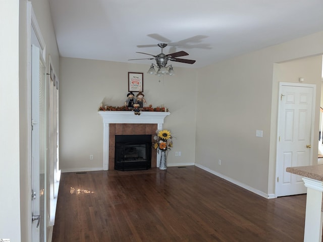 unfurnished living room with ceiling fan, dark hardwood / wood-style floors, and a fireplace