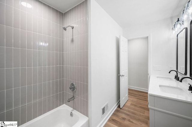 bathroom featuring vanity, tiled shower / bath, and wood-type flooring