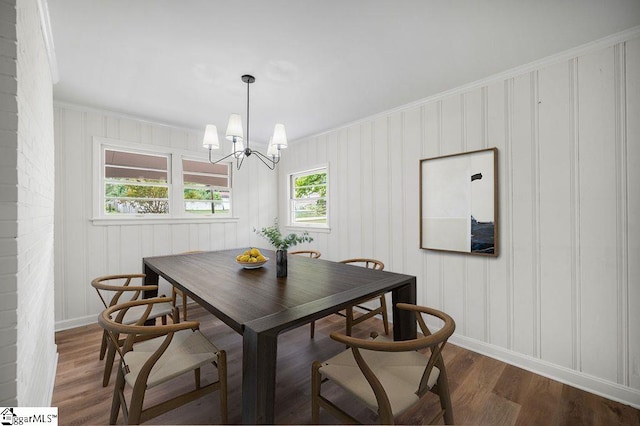 dining room with dark wood-type flooring, a notable chandelier, and ornamental molding