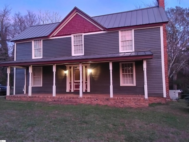 farmhouse inspired home featuring a yard and a porch