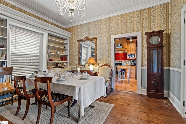 dining area with a chandelier, crown molding, and dark hardwood / wood-style flooring