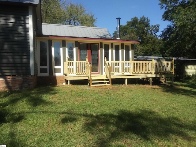 rear view of house featuring a yard and a deck