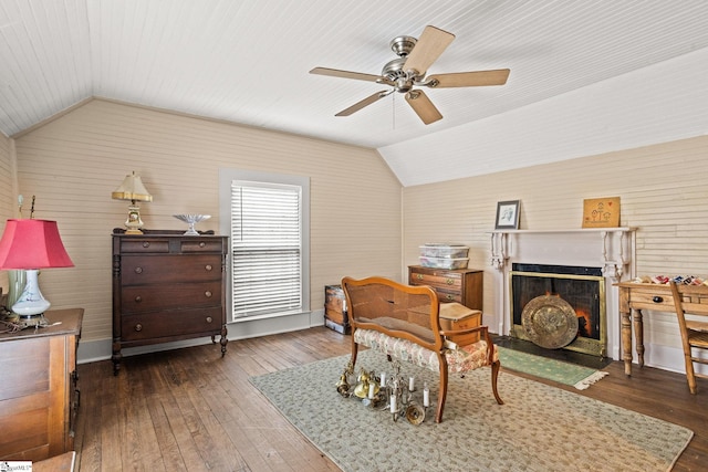 living area featuring lofted ceiling, dark wood-type flooring, and ceiling fan