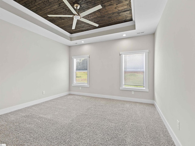 spare room with ceiling fan, carpet floors, wooden ceiling, and a raised ceiling