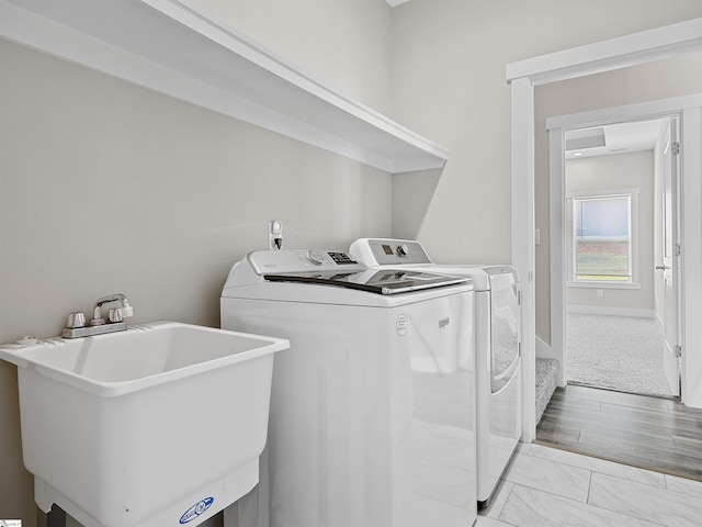 laundry area featuring light hardwood / wood-style floors, sink, and independent washer and dryer