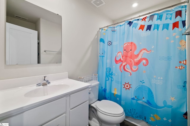 bathroom with vanity, a shower with shower curtain, and toilet