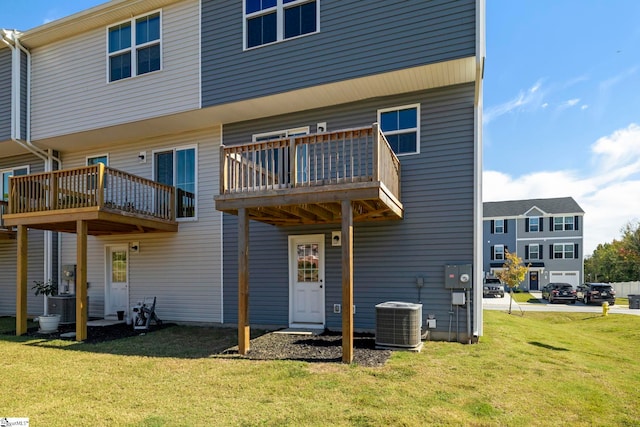 back of house featuring a lawn, a balcony, and central AC unit