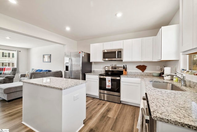 kitchen featuring light hardwood / wood-style floors, sink, stainless steel appliances, and a wealth of natural light