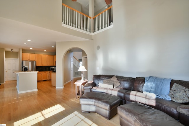 living room with a high ceiling and light wood-type flooring