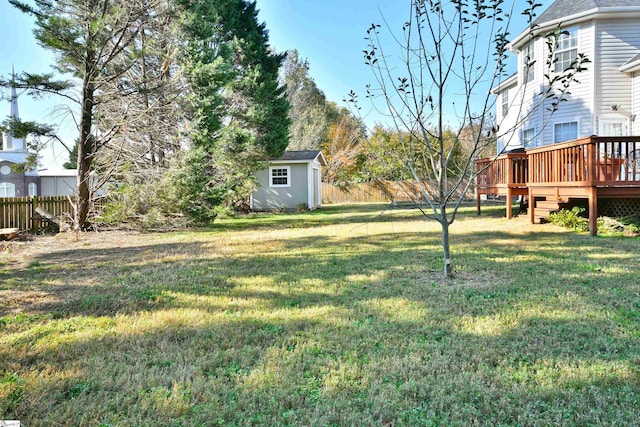 view of yard featuring a wooden deck and a storage unit