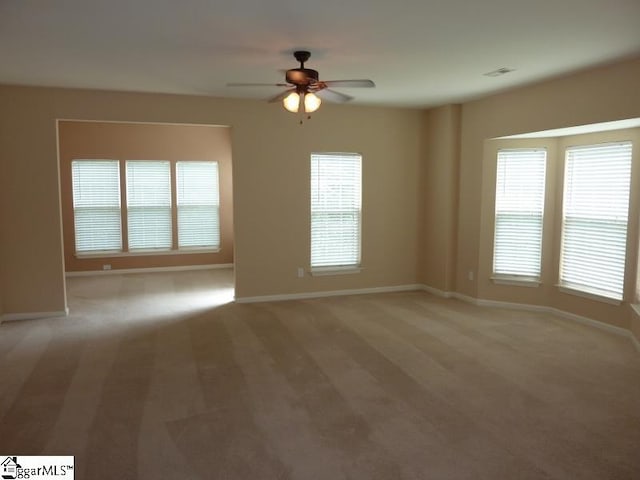 spare room with light colored carpet and ceiling fan