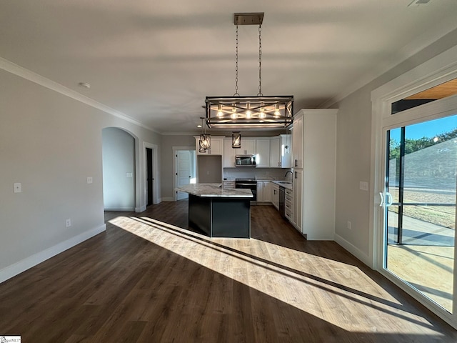 kitchen featuring a kitchen island, white cabinetry, dark wood-type flooring, sink, and decorative light fixtures