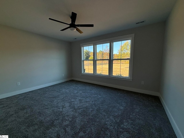 unfurnished room featuring dark carpet and ceiling fan