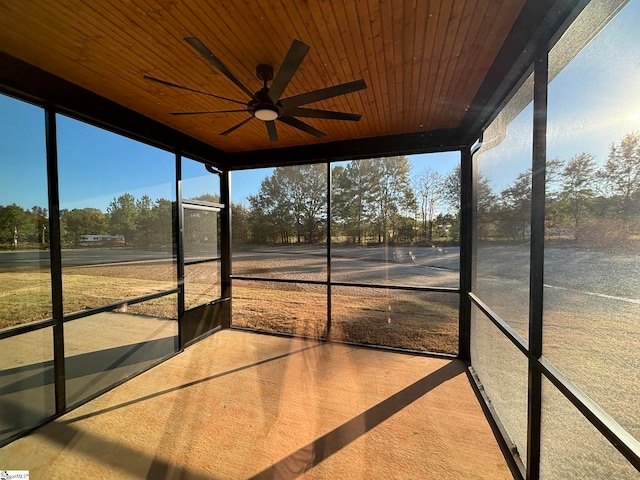 unfurnished sunroom featuring wood ceiling and ceiling fan