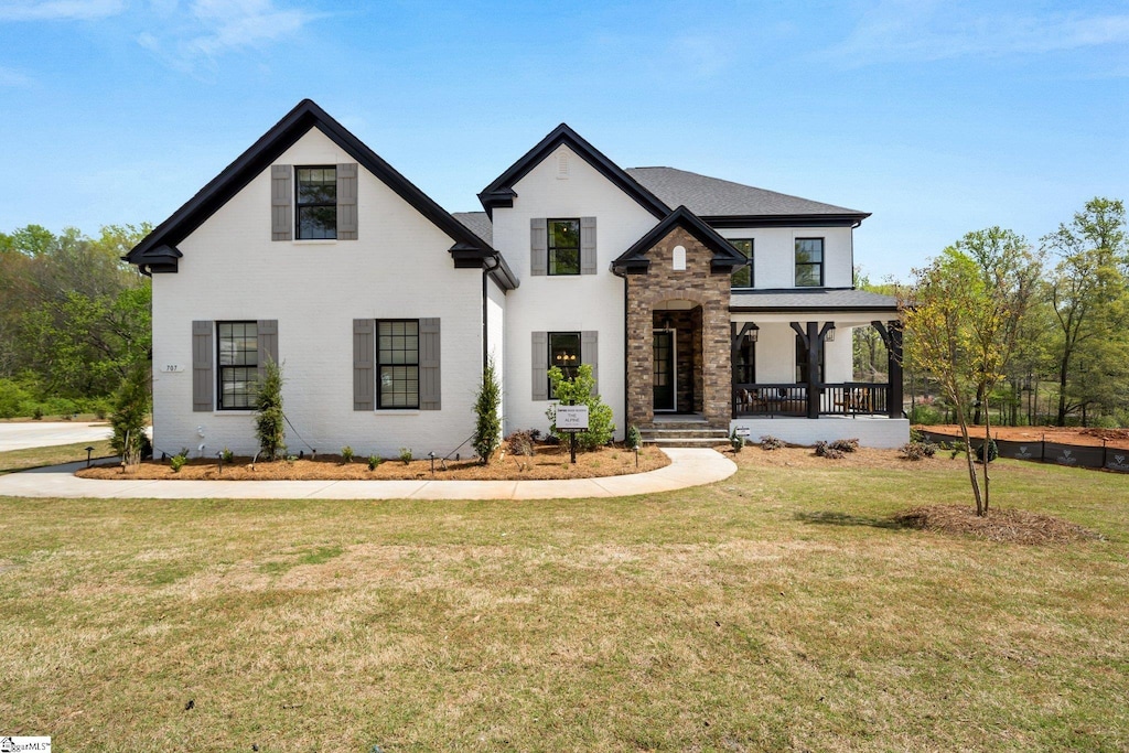 view of front of house featuring covered porch and a front lawn