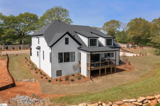 rear view of house with a yard and a deck