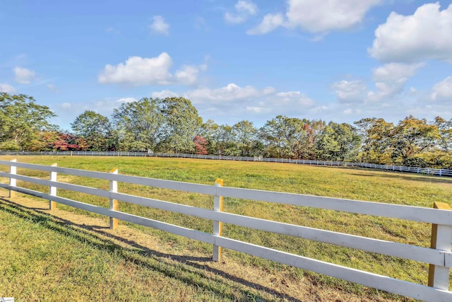 view of gate with a yard and a rural view