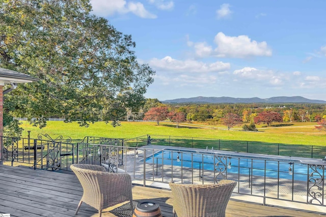 view of pool featuring a deck with mountain view and a yard