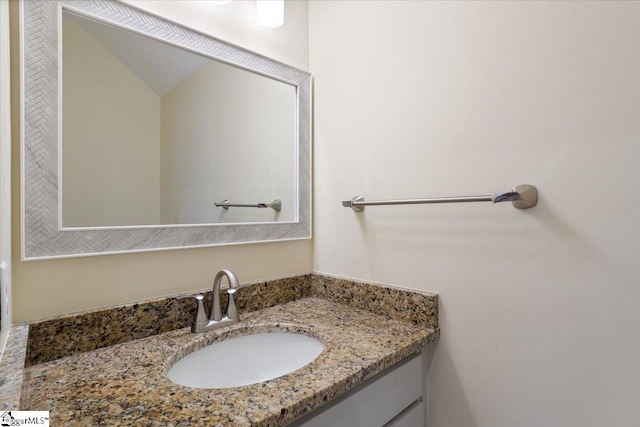 bathroom with vanity and lofted ceiling