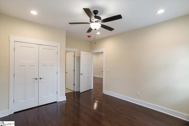 unfurnished bedroom with dark wood-type flooring, a closet, and ceiling fan