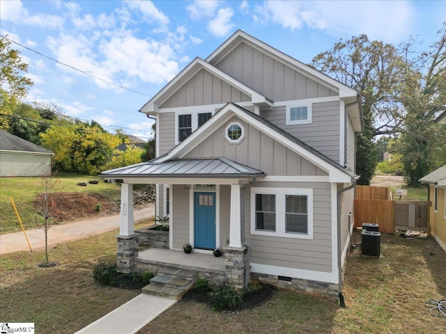 view of front of house featuring a front lawn and central AC