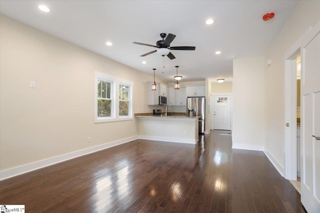 unfurnished living room featuring sink, dark hardwood / wood-style floors, and ceiling fan