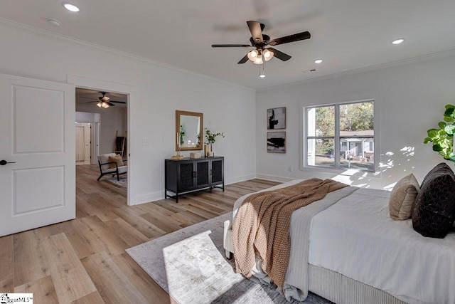 bedroom featuring light hardwood / wood-style flooring, ornamental molding, and ceiling fan