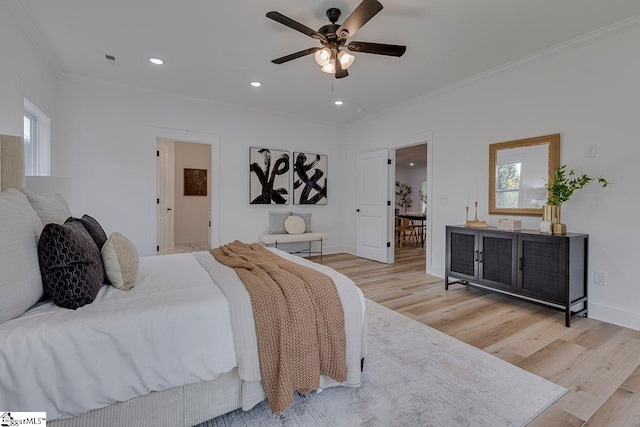 bedroom featuring ornamental molding, ensuite bathroom, light wood-type flooring, and ceiling fan