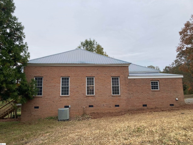 view of property exterior with a yard and central AC unit