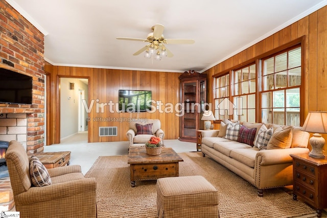 carpeted living room with ornamental molding, wooden walls, and ceiling fan