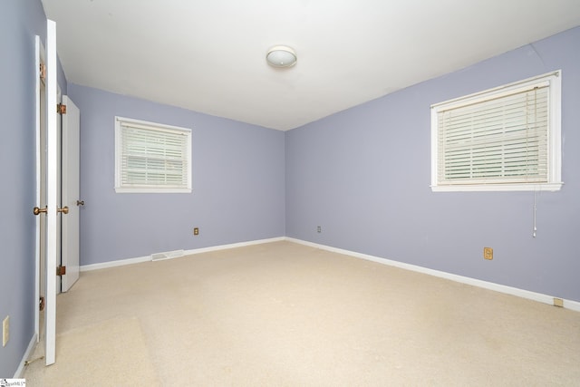 unfurnished bedroom with light carpet and multiple windows