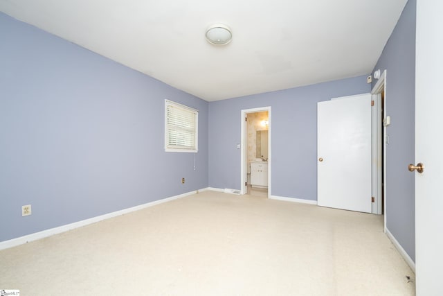 unfurnished bedroom featuring ensuite bathroom and carpet flooring